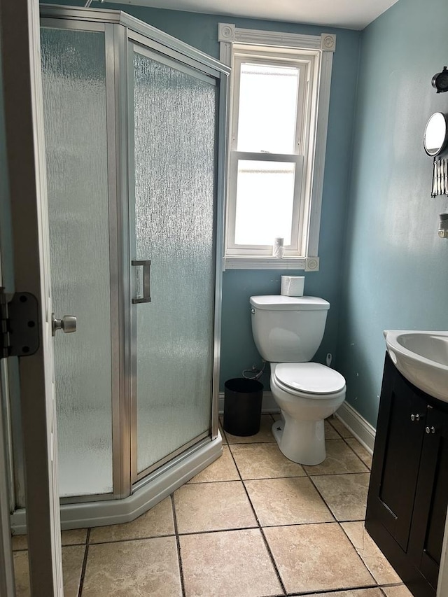 bathroom featuring tile patterned flooring, vanity, toilet, and an enclosed shower