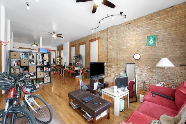 living room with light wood-type flooring and brick wall