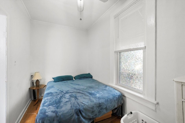 bedroom with hardwood / wood-style flooring, ceiling fan, and ornamental molding