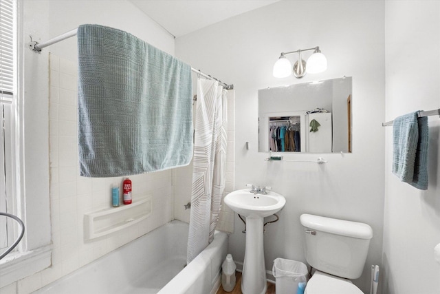 bathroom featuring shower / bath combination with curtain and toilet