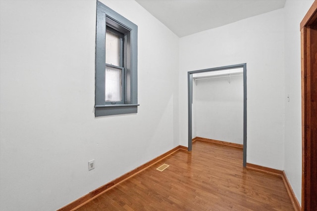 unfurnished bedroom with light wood-type flooring and a closet