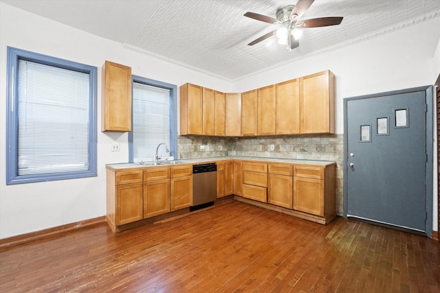 kitchen featuring decorative backsplash, dark hardwood / wood-style flooring, stainless steel dishwasher, ceiling fan, and crown molding