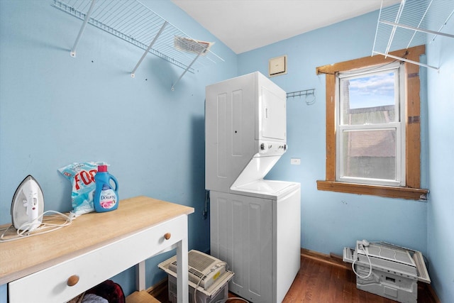 laundry room featuring dark wood-type flooring and stacked washer / drying machine