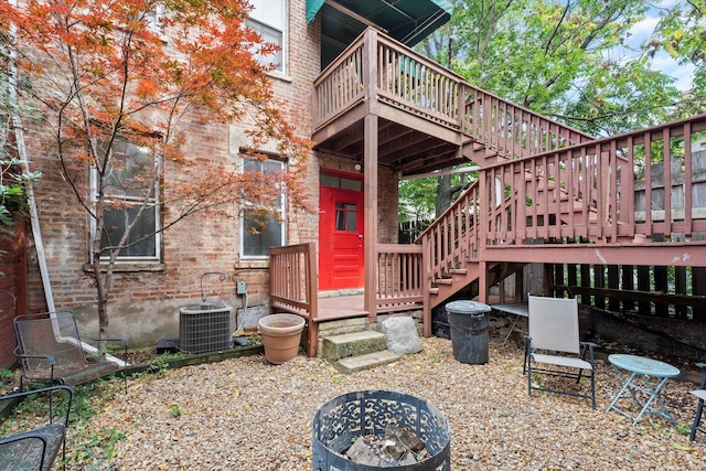 exterior space with a fire pit, a deck, and central air condition unit