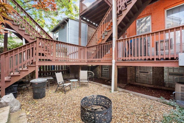 rear view of property with a fire pit and cooling unit