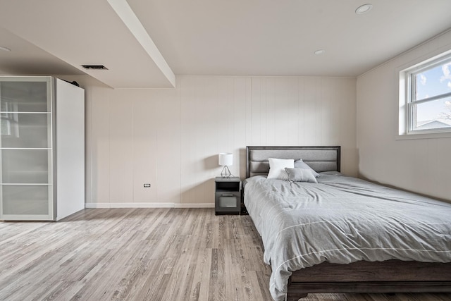 bedroom featuring wood walls and light wood-type flooring