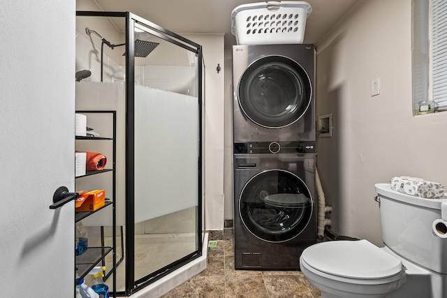 bathroom featuring toilet, stacked washer and dryer, and walk in shower