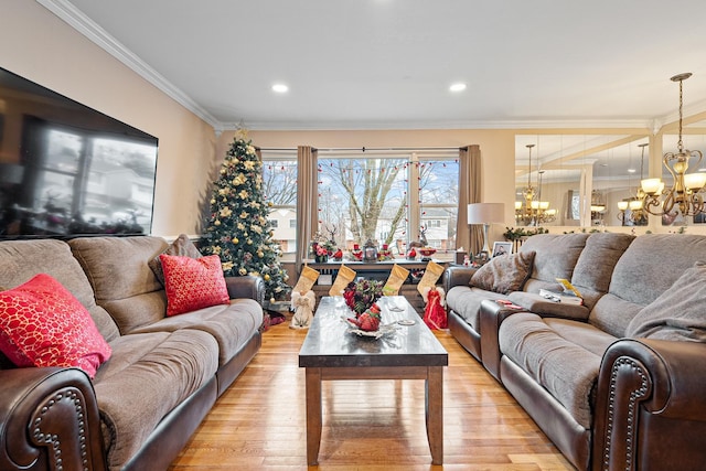 living room featuring light hardwood / wood-style floors, crown molding, and a notable chandelier