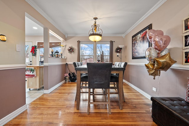 dining room featuring light hardwood / wood-style floors and crown molding