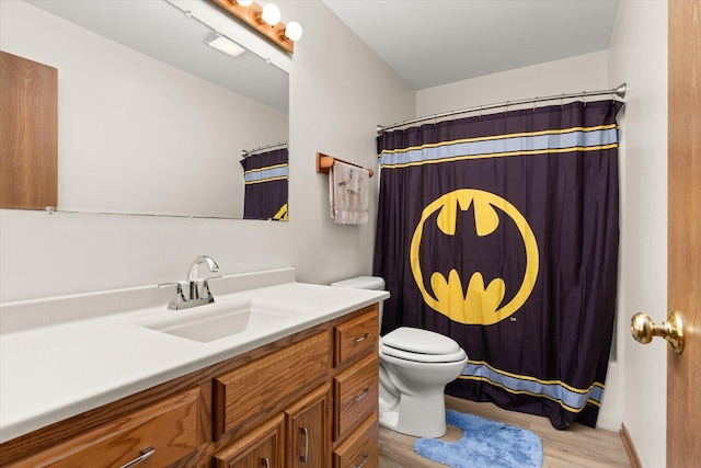 bathroom featuring vanity, hardwood / wood-style flooring, toilet, and walk in shower