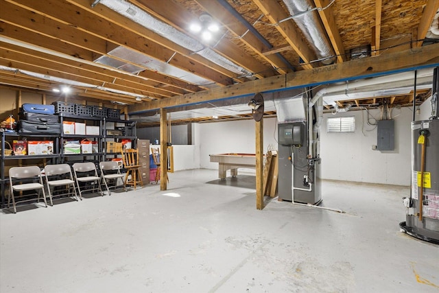 basement featuring electric panel, gas water heater, heating unit, and pool table