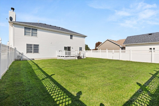 back of house with a deck and a lawn