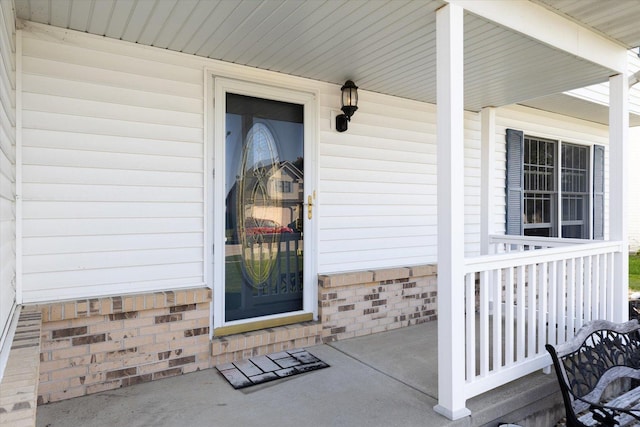 view of exterior entry featuring covered porch