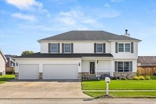 front facade featuring a front lawn and a garage