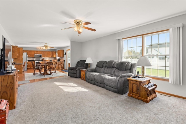 carpeted living room featuring ceiling fan and a healthy amount of sunlight