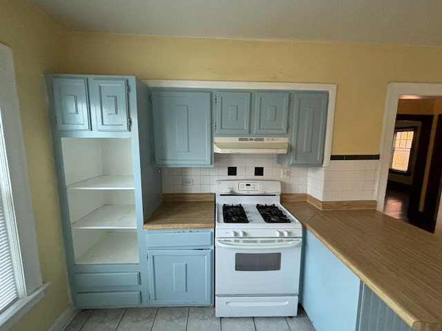 kitchen with tasteful backsplash, gas range gas stove, and light tile patterned flooring