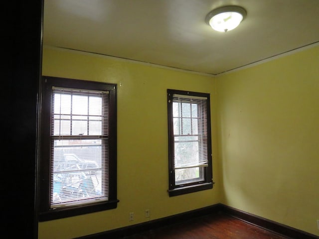 unfurnished room featuring dark hardwood / wood-style flooring and plenty of natural light