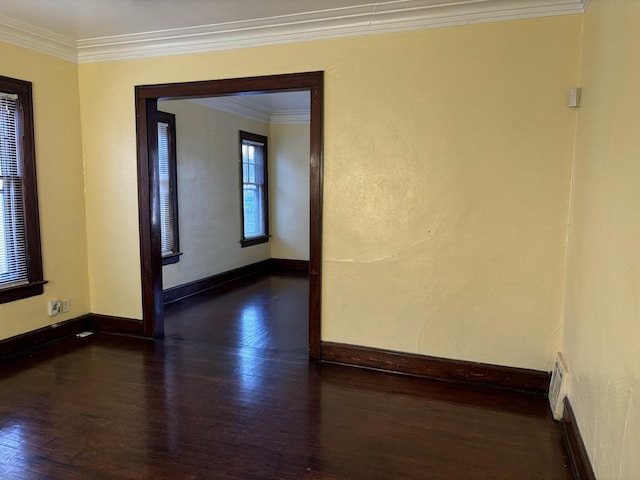 spare room featuring dark hardwood / wood-style flooring and crown molding