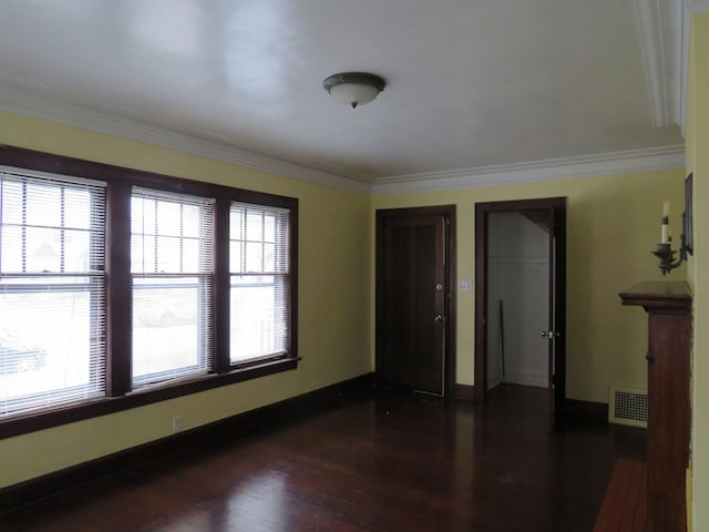 empty room featuring dark hardwood / wood-style floors and crown molding