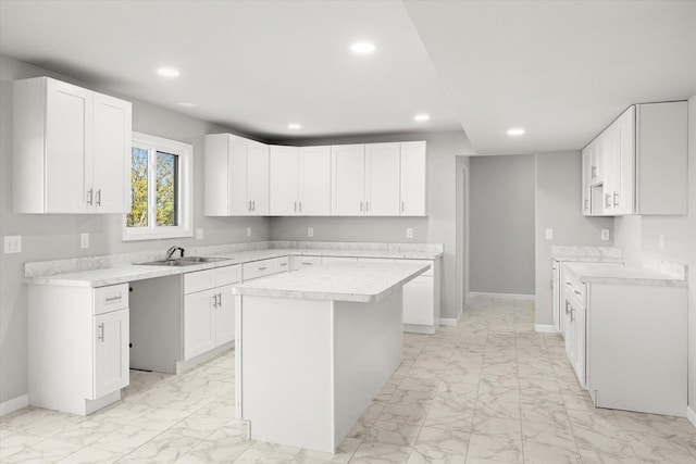 kitchen featuring marble finish floor, a kitchen island, light countertops, and recessed lighting