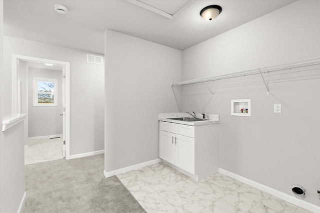 clothes washing area featuring cabinets, sink, light colored carpet, and washer hookup