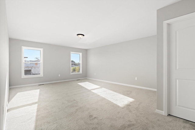 unfurnished room featuring light carpet