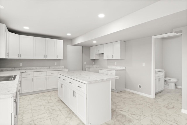 kitchen featuring a center island, white cabinetry, and sink