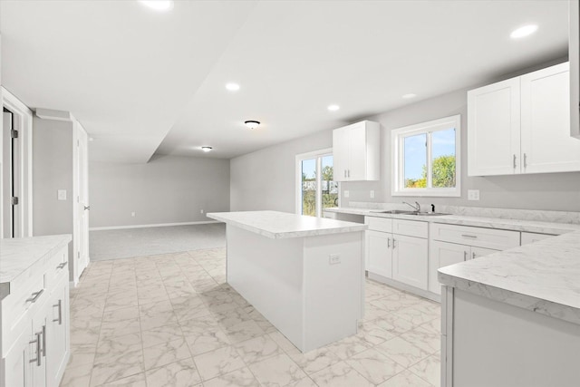 kitchen featuring a center island, white cabinetry, and sink