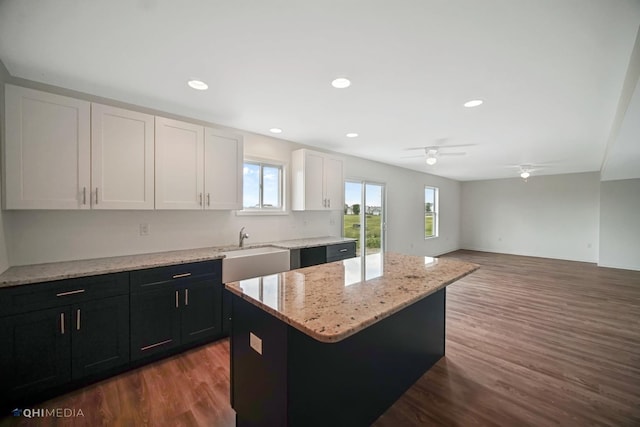 kitchen with a center island, white cabinets, sink, ceiling fan, and dark hardwood / wood-style floors