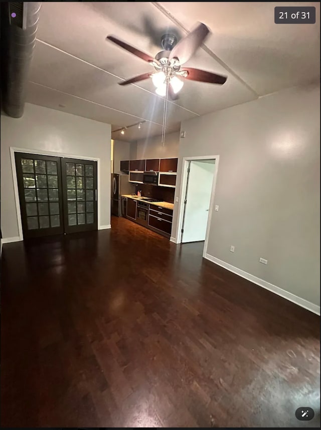 unfurnished living room featuring ceiling fan and dark wood-type flooring