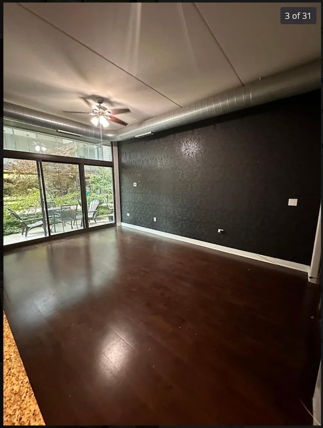 unfurnished room with ceiling fan and expansive windows