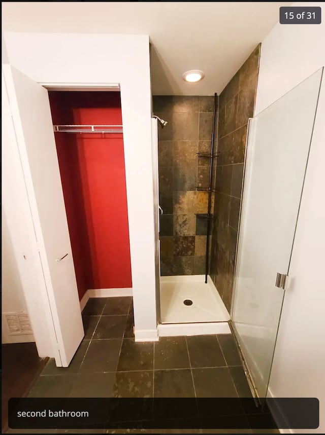 bathroom with tile patterned floors and a tile shower