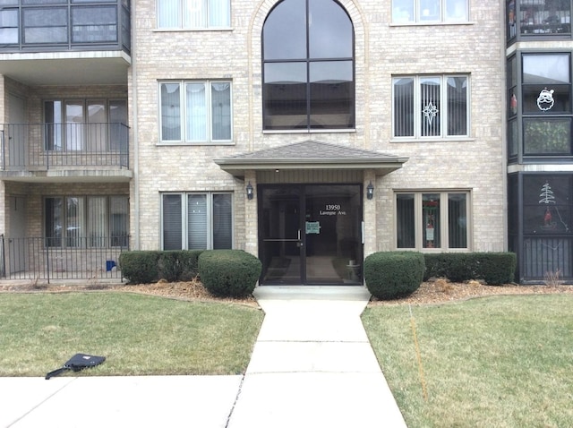 view of exterior entry with a lawn