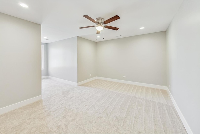 spare room featuring light carpet and ceiling fan