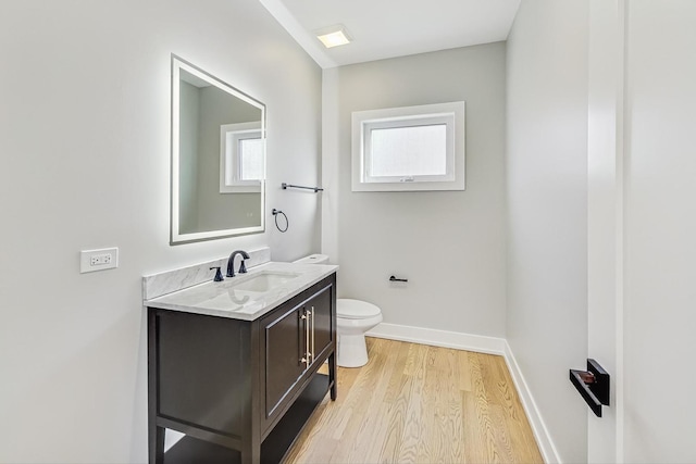 bathroom with toilet, hardwood / wood-style flooring, and vanity