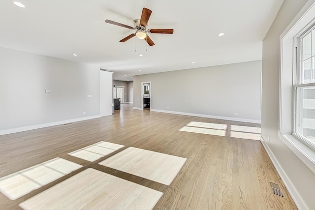 unfurnished living room with ceiling fan, a healthy amount of sunlight, and light hardwood / wood-style floors