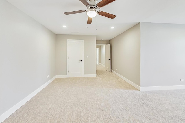 carpeted spare room with ceiling fan