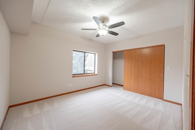 unfurnished bedroom featuring ceiling fan, light carpet, and a closet