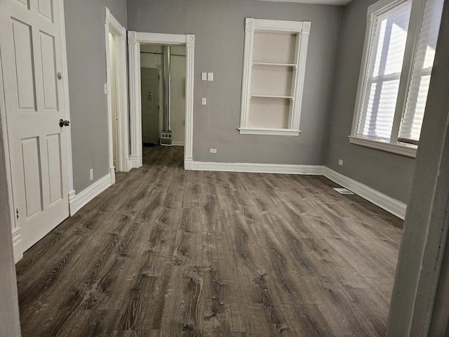 unfurnished bedroom with dark hardwood / wood-style floors