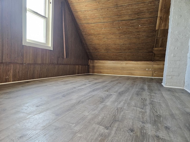 bonus room featuring hardwood / wood-style floors, wood ceiling, wooden walls, and vaulted ceiling