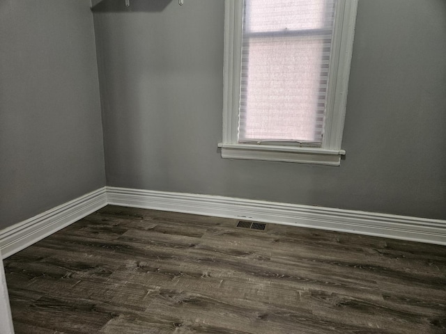 unfurnished room with a healthy amount of sunlight and dark hardwood / wood-style floors