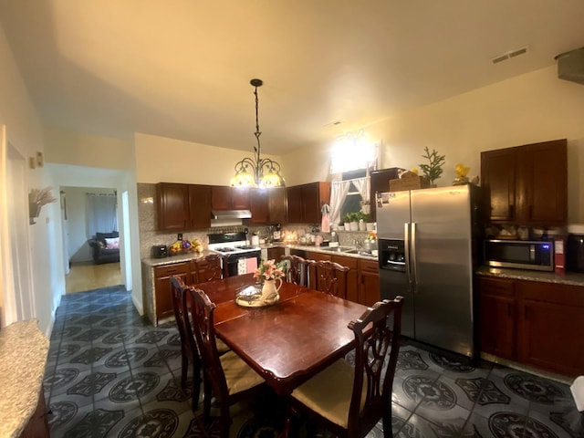 dining room with sink and a chandelier