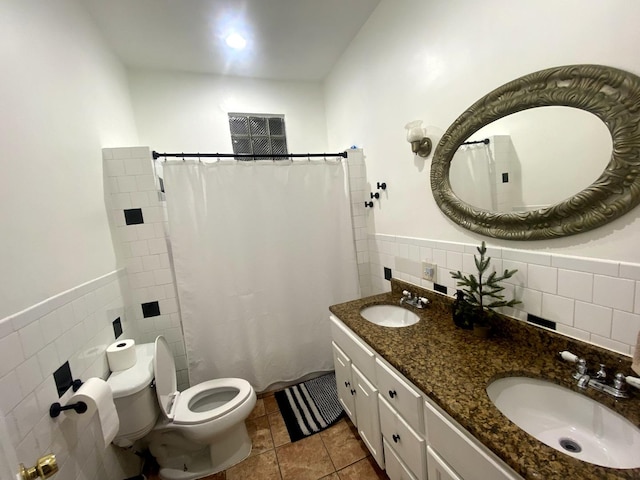 bathroom with a shower with shower curtain, tile patterned floors, vanity, tile walls, and toilet