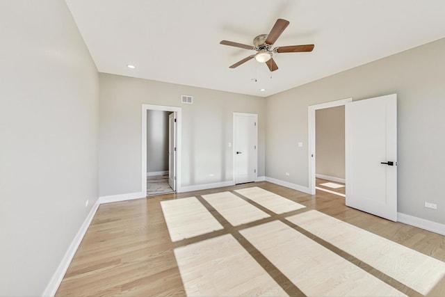 unfurnished bedroom featuring light hardwood / wood-style floors, ensuite bath, and ceiling fan