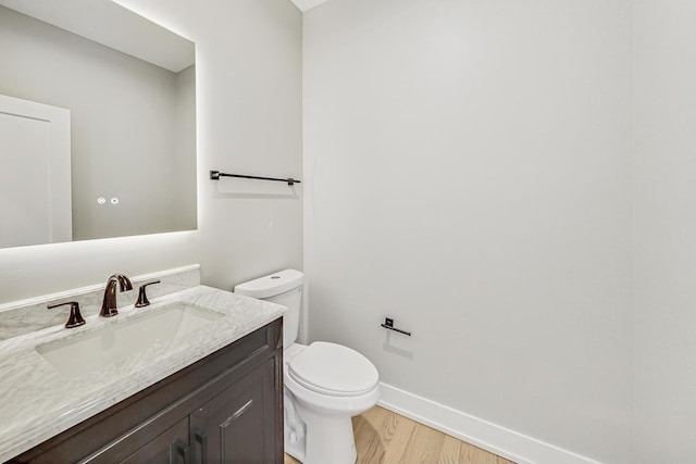 bathroom featuring hardwood / wood-style flooring, vanity, and toilet