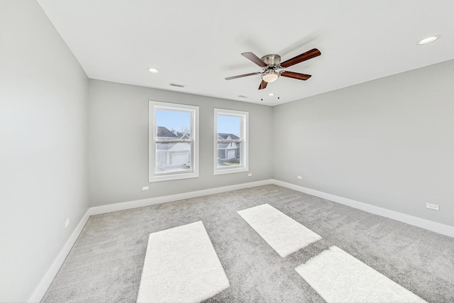 unfurnished room featuring ceiling fan and light carpet