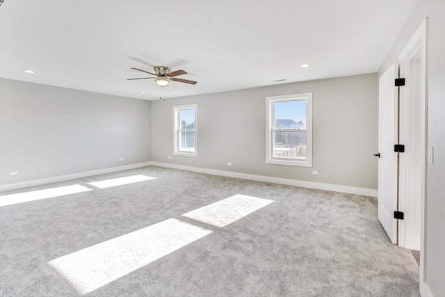 spare room with ceiling fan and light carpet