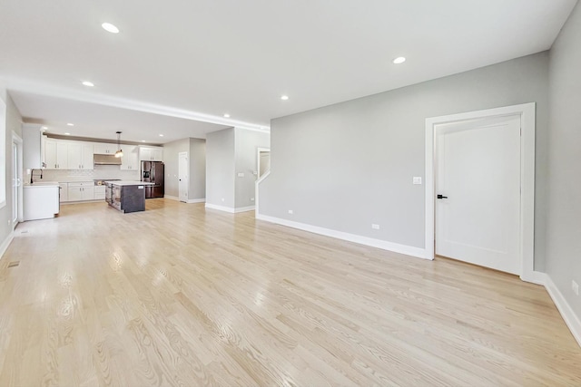 unfurnished living room with light wood-type flooring and sink