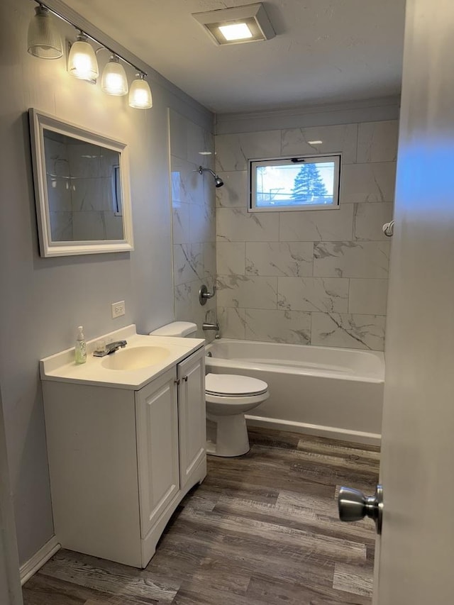 full bathroom with toilet, vanity, wood-type flooring, and tiled shower / bath