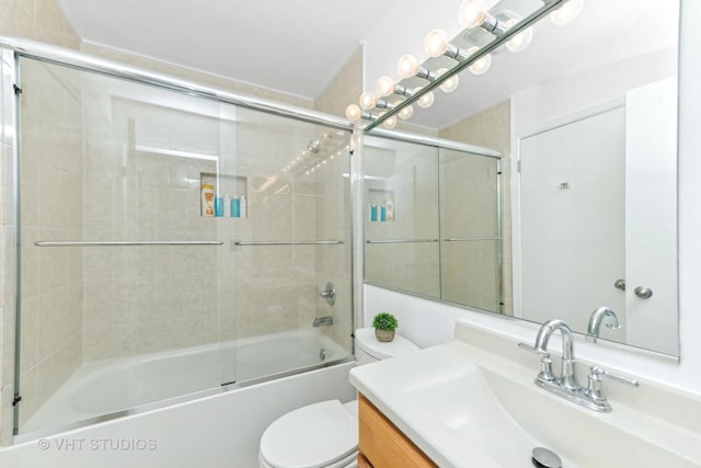 full bathroom featuring vanity, combined bath / shower with glass door, and toilet